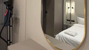 A modern hotel room with a large mirror, a bed, a wardrobe, and an air conditioning unit. - 103 tara-JRE Al Lweibdeh 2BDR duplex apartment (Amman)