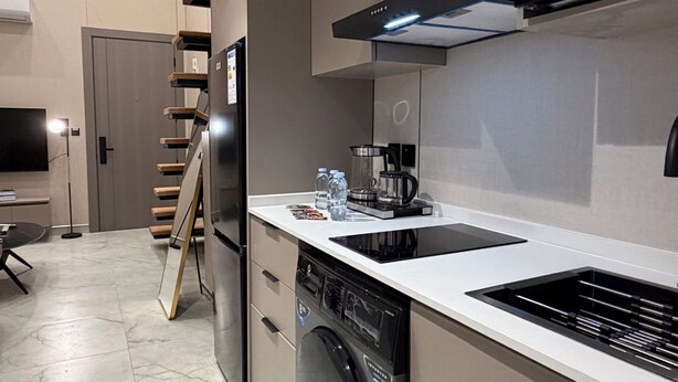 A modern kitchen with a dishwasher, a coffee maker, and a microwave. - 103 tara-JRE Al Lweibdeh 2BDR duplex apartment (Amman)