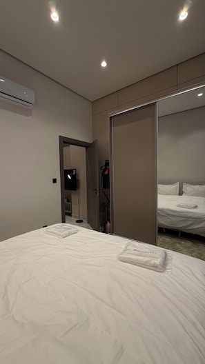 Une chambre d’hôtel équipée d’un lit, d’une armoire, d’une télévision et d’un appareil de climatisation.