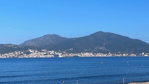 A coastal cityscape with a mountain in the background. - PORTICCIO center Magnificent T2 with view (Grosseto-Prugna)