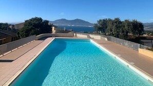 A clear blue swimming pool with a view of mountains and a clear sky. - 2-room apartment in residence with swimming pool overlooking Ajaccio bay (Porticcio)