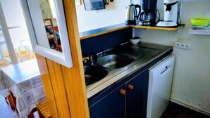 A compact kitchen with a sink, a coffee maker, and a dishwasher. - 2-room apartment in residence with swimming pool overlooking Ajaccio bay (Porticcio)