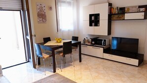 Ett modernt kök med matplats, TV och mikrovågsugn.