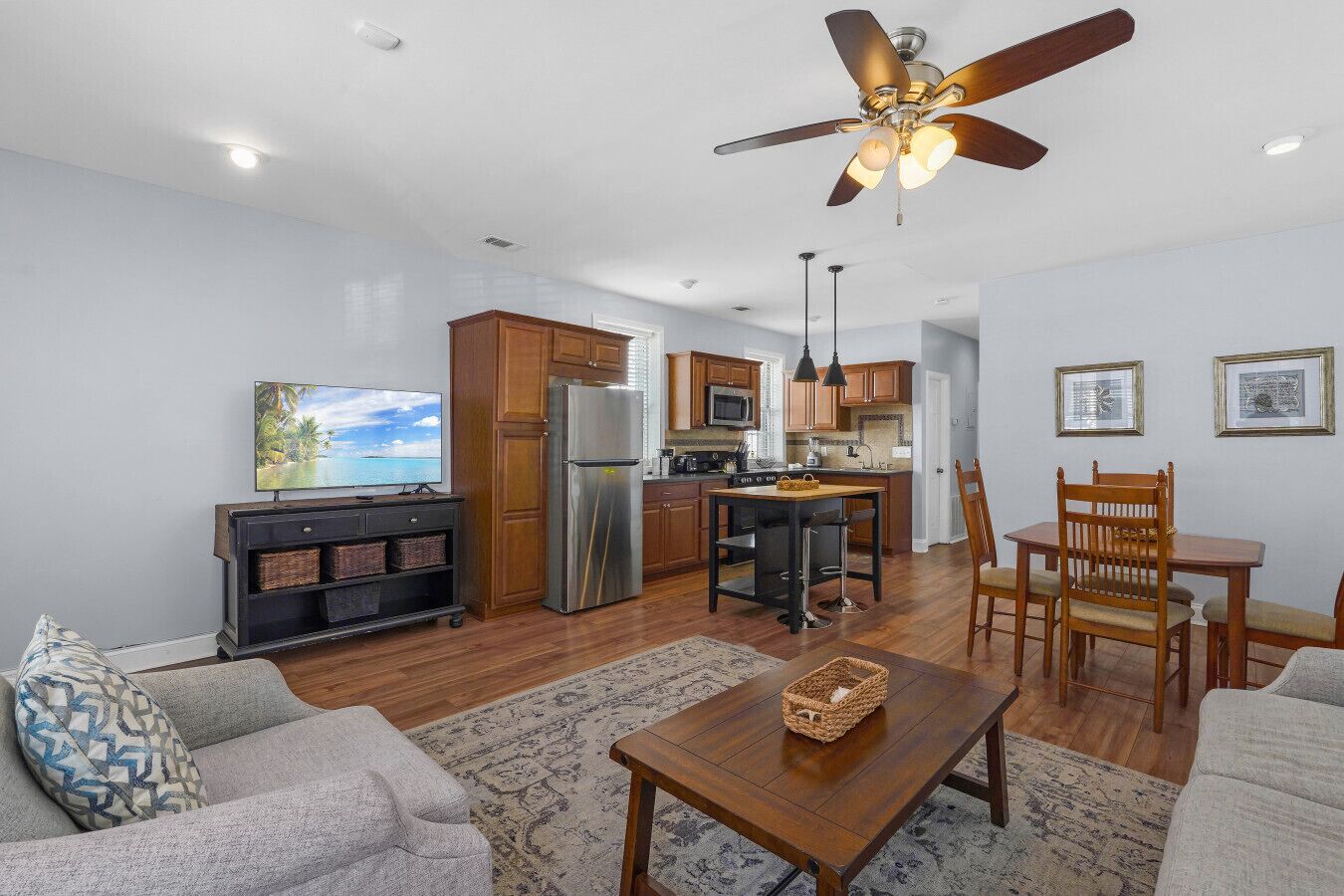 A modern kitchen with a refrigerator, microwave, and dining area with chairs and a table.