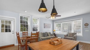 A dining area with a wooden table, chairs, and a ceiling fan. - Lower Carriage House at Wayne Mansion Estate (Savannah)