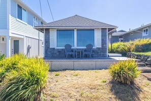A residential house with a porch, two chairs, and a small garden area. - Lighthouse Lookout at Nye Beach * Ocean View (Newport)