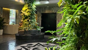 A spacious atrium with a high ceiling, large windows, and lush vertical gardens. - Bay Four Seasons Castle Hotel (Weihai)