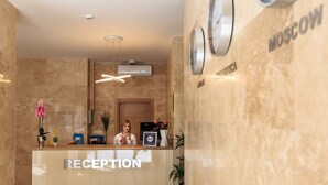 A reception desk with a 'RECEPTION' sign, a clock, and a 'MOSCOW' sign on the wall.