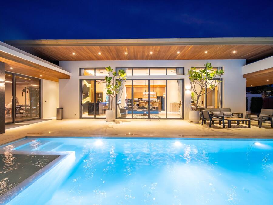 A modern house with a swimming pool, large windows, and outdoor seating.