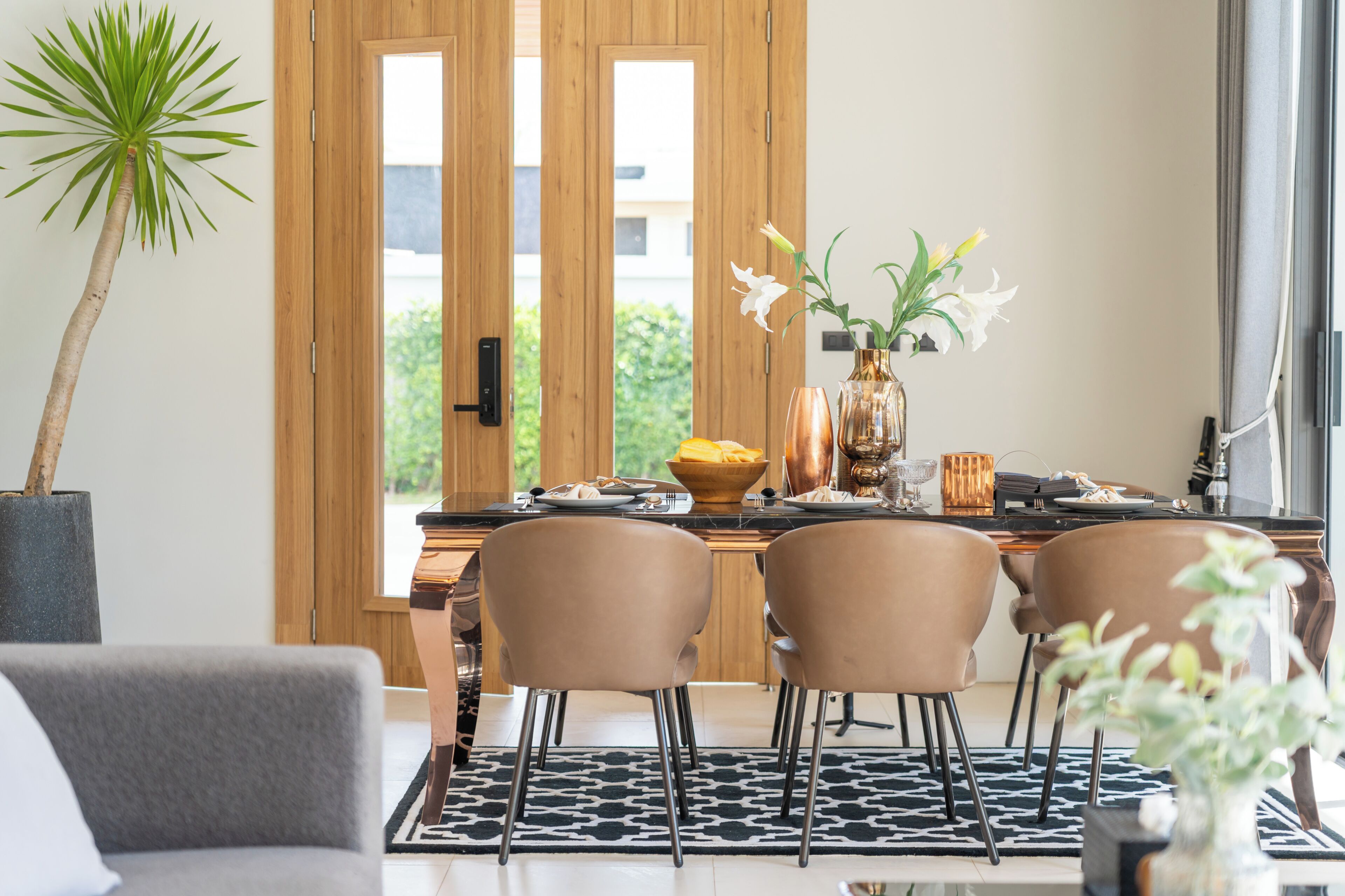 A dining area with a wooden door, a plant, and a table set for four.