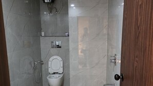 A bathroom with a toilet, bidet, and shower. - Hotel Shravan Royal Inn  (Jaipur)
