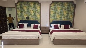 A hotel room with two beds, a large mirror, and a decorative wall. - Hotel Shravan Royal Inn  (Jaipur)