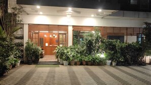 A hotel entrance with a paved walkway, potted plants, and a reception area. - WHITE FORT THEKKADY (Kumily)