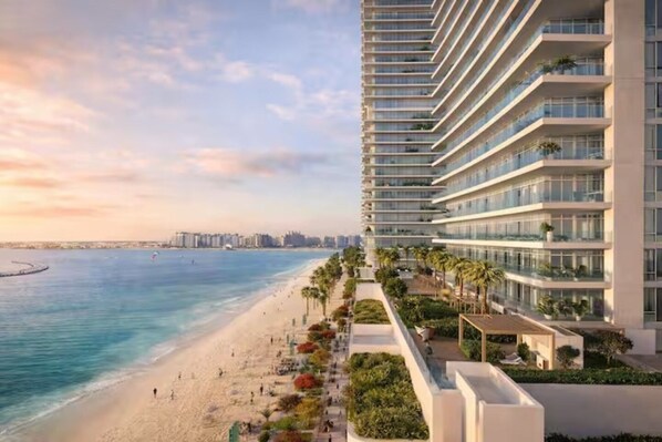 A high-rise hotel with a beach view, multiple balconies, and a landscaped terrace.