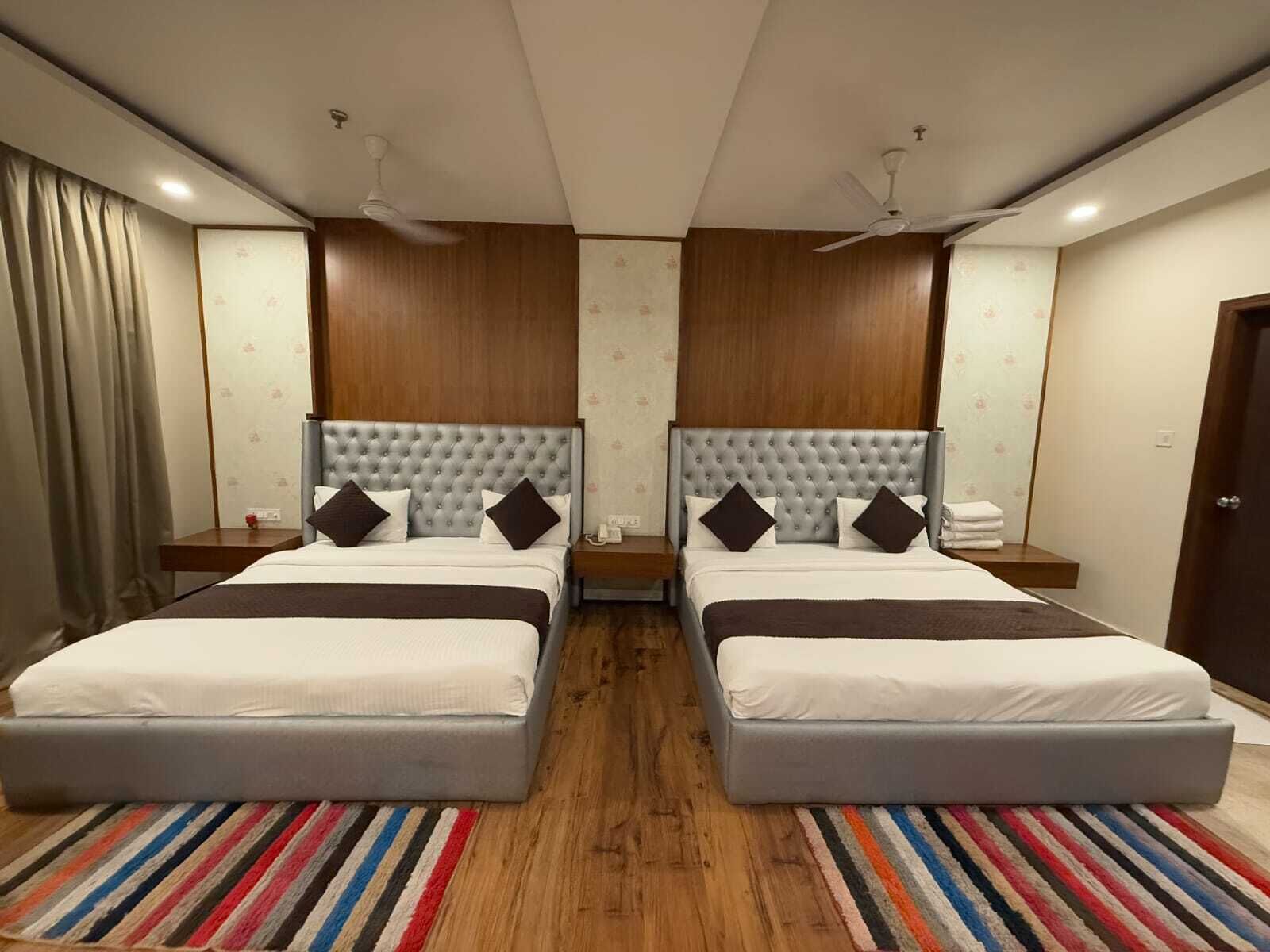 A double bed room with two nightstands, a striped rug, and a ceiling fan.