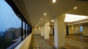 Um interior espaçoso com um corredor comprido, janelas amplas e teto alto.