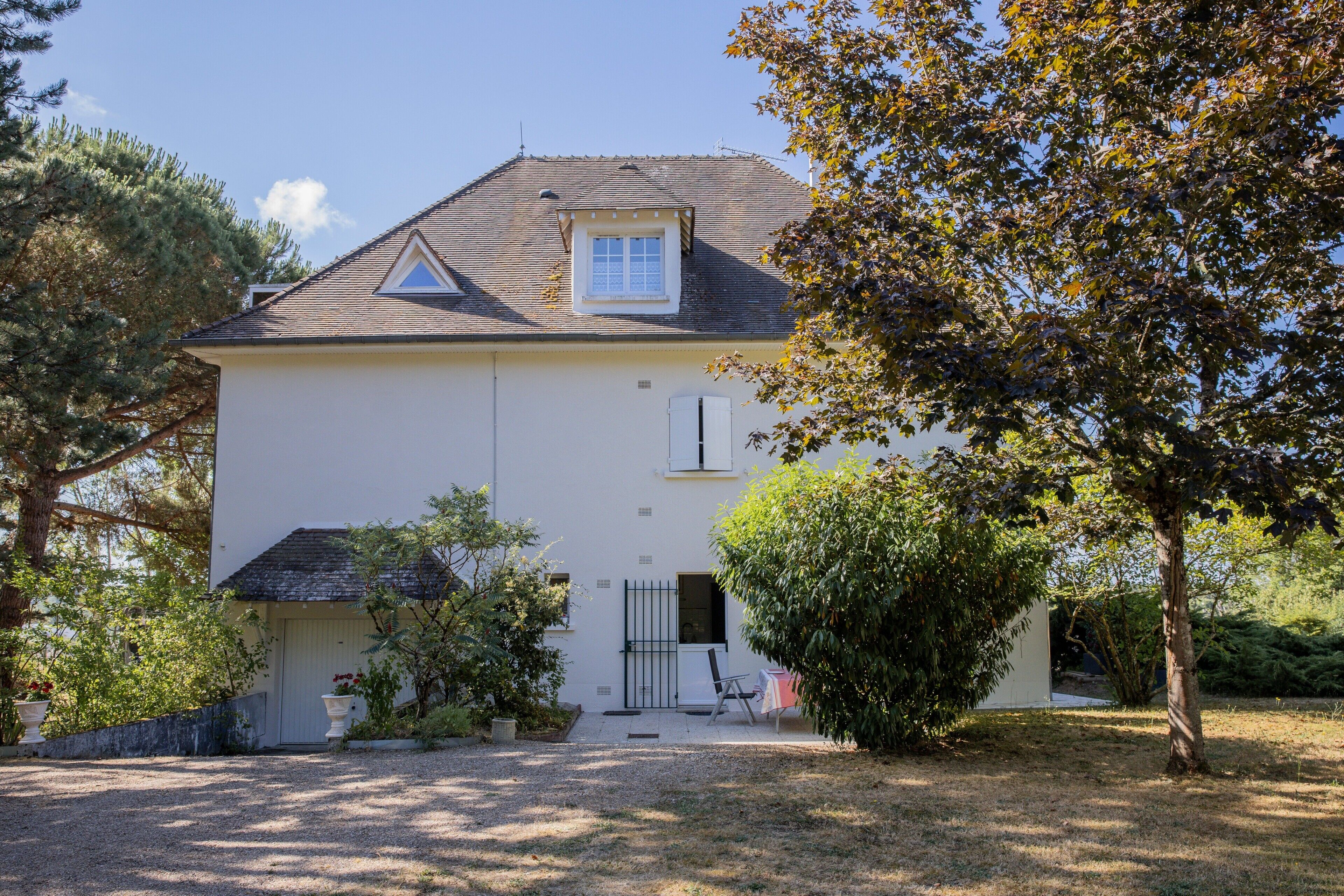 A two-story house with a sloped roof, a small balcony, and a front door.