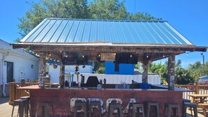 A bar with a blue roof, wooden stools, and a sign that reads 'BAR'. - "Catch of the Day" 2bdr 1.5bth -Water Front Home @Pier 98 Marina...BOOK TODAY (Panama City)