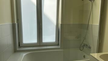 Eenvoudig appartement | Badkamer | Een bad/douchecombinatie, gratis toiletartikelen, een haardroger