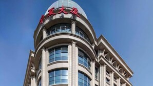 A multi-story hotel with a curved facade, large windows, and a prominent entrance. - Beijing Ningxia Hotel (Beijing)