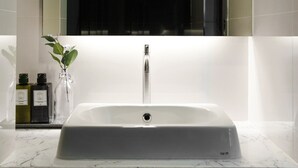 A bathroom with a white sink, a mirror, and a towel rack. - B48 Hotel (Bangkok)