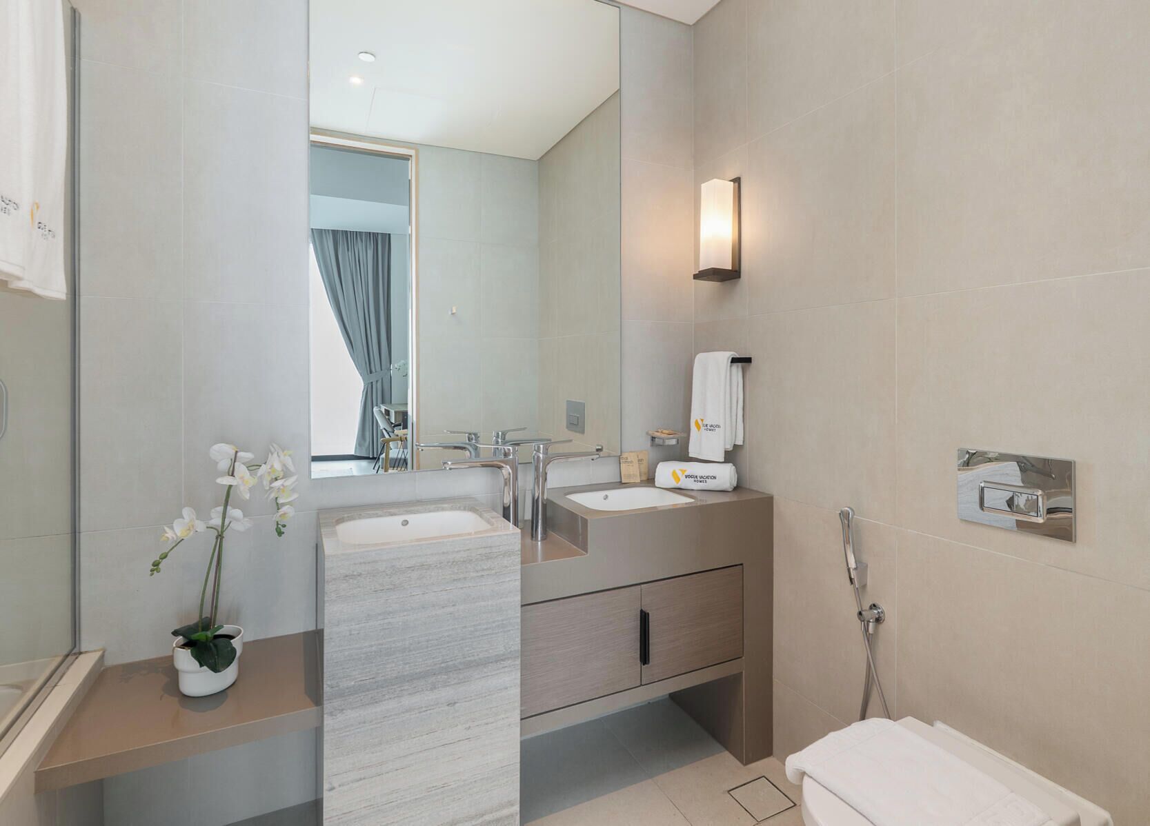 A modern bathroom with a marble sink, two sinks, a mirror, a towel rack, and a shower.