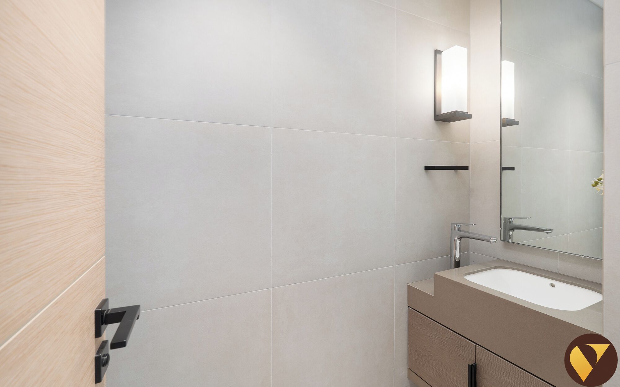 Une salle de bain moderne avec un lavabo, un miroir et un luminaire.