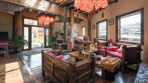 A rustic interior with wooden furniture, a high ceiling, and large windows. - Shangri-La Chang Palace (Shangri-La)