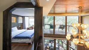 A bedroom with a large bed, wooden ceiling, and a view of an outdoor deck. - Shangri-La Chang Palace (Shangri-La)