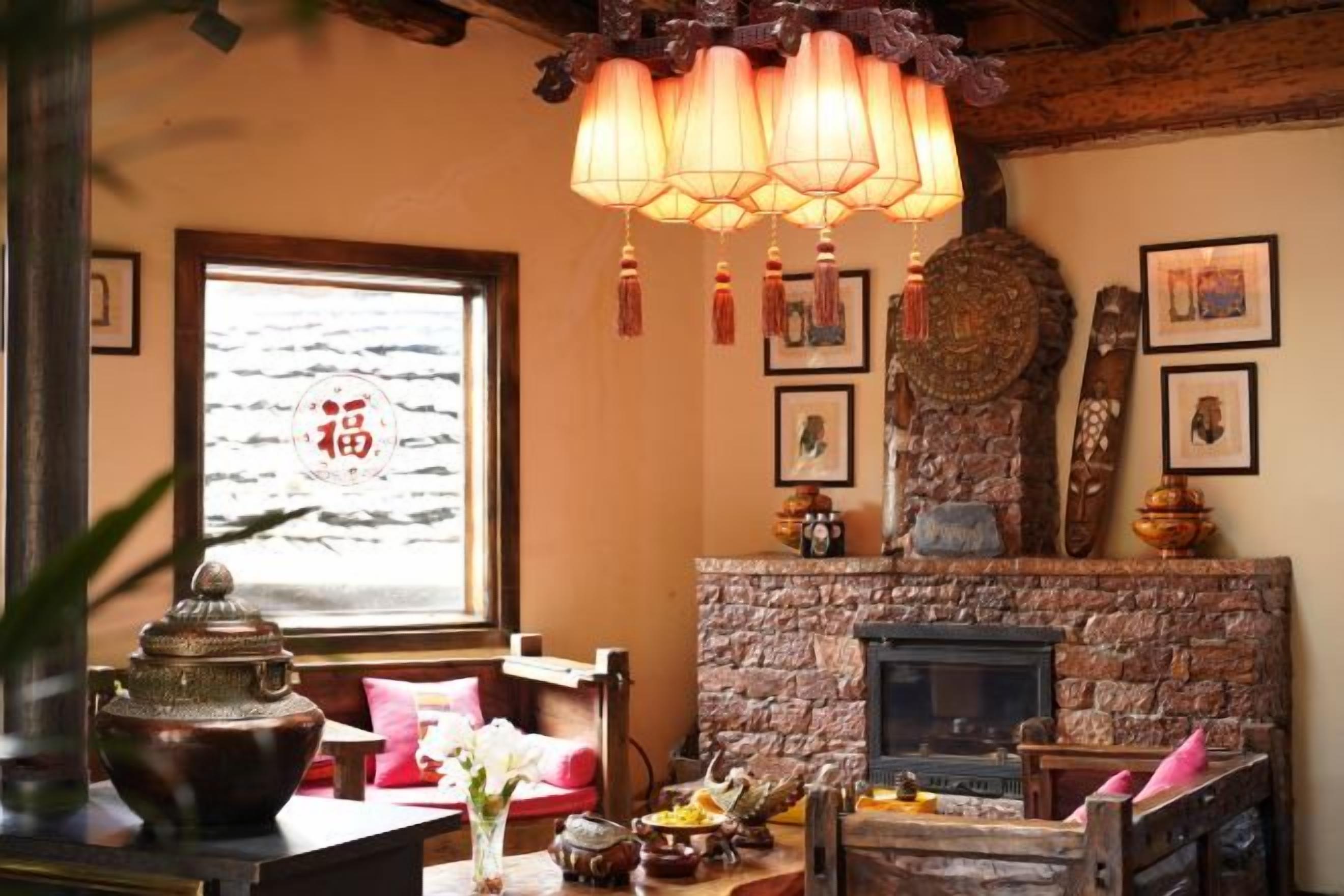 Una habitación tradicional con chimenea de piedra, techo de madera y un amplio ventanal con vistas.