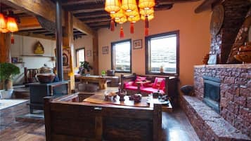 A cozy interior with a wooden dining table, a fireplace, and a view of the outdoors.