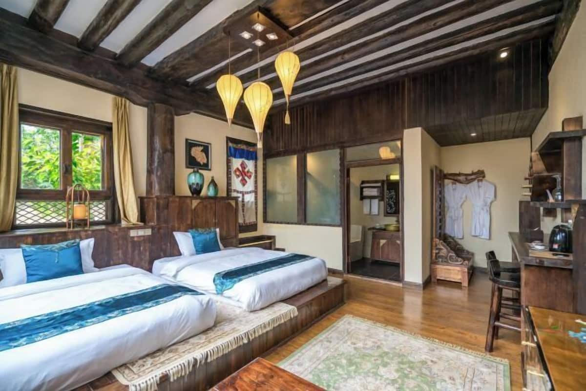 Une chambre avec deux lits, un plafond en bois et une vue sur l’extérieur.