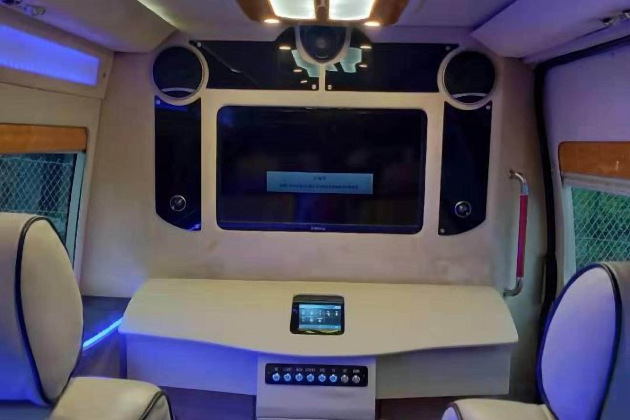 A modern interior with a central table, seating, and a control panel.