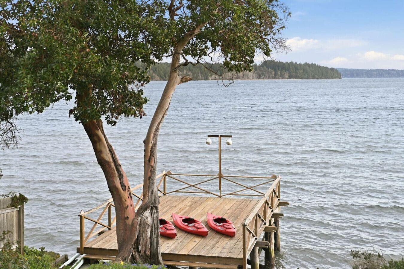 A wooden dock with kayaks and a light fixture.