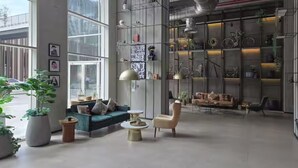 Un intérieur moderne avec un canapé, un fauteuil et une table basse, une bibliothèque et une grande fenêtre.