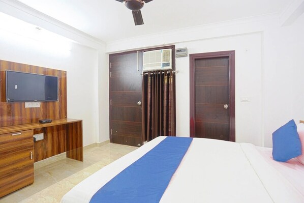 A hotel room with a bed, a desk, a TV, and a wardrobe. - Hotel Dream Connect - Sector 38 (Gurugram)