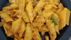 Un plato de pasta con salsa de tomate, adornado con hierbas y especias.