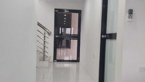 A hallway with a glass door, a metal railing, and a ceiling light. - Whitehaven Apartment in Lautoka, Fiji (Lautoka)