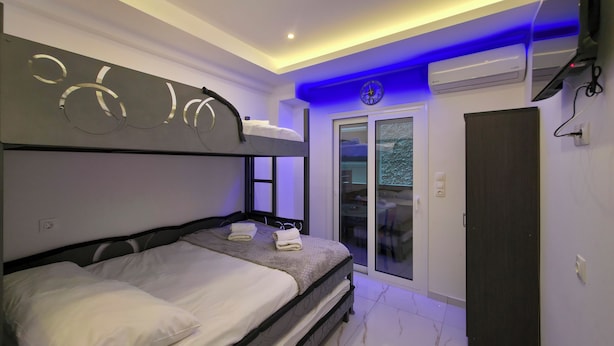 A modern bedroom with bunk beds, a sliding glass door, and an air conditioning unit. - 8A - Alexandros Apartment by SDR (Paralia)