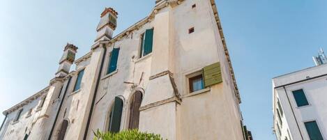A historic building with a symmetrical facade, arched windows, and a central entrance.