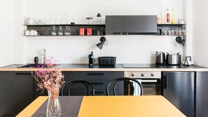 Een koffiezetapparaat/waterkoker, een koelkast, een oven, een kookplaat