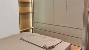 A bedroom with a bed, a wooden shelf unit, and a wardrobe with sliding doors. - GH3-Glory Hieght- Vinhome Grand Park (Ho Chi Minh City)