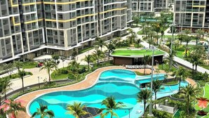 A modern hotel complex with multiple high-rise buildings, a large central swimming pool, and surrounding greenery. - GH3-Glory Hieght- Vinhome Grand Park (Ho Chi Minh City)