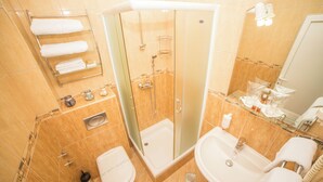 A bathroom with a glass-enclosed shower, a toilet, a sink, and a towel rack. - Hotel Fiammanti (Đenovići)