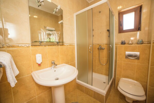 A bathroom with a sink, toilet, and glass-enclosed shower. - Hotel Fiammanti (Đenovići)