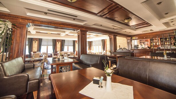 A hotel lobby with a bar area, leather seating, and a reception desk. - Hotel Fiammanti (Đenovići)