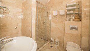 A bathroom with a glass-enclosed shower, a white sink, and a toilet. - Hotel Fiammanti (Đenovići)