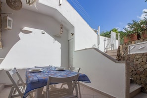 A white exterior wall with a stone wall and a white gate. - GuestHost - A comfortable and welcoming 45 square meters apartment, perfect for two people, located on the lower ground floor of a building without an elevator.The property is ideally located, just a 4-minute walk from the beach: our guests can enjoy the (Golfo Aranci)