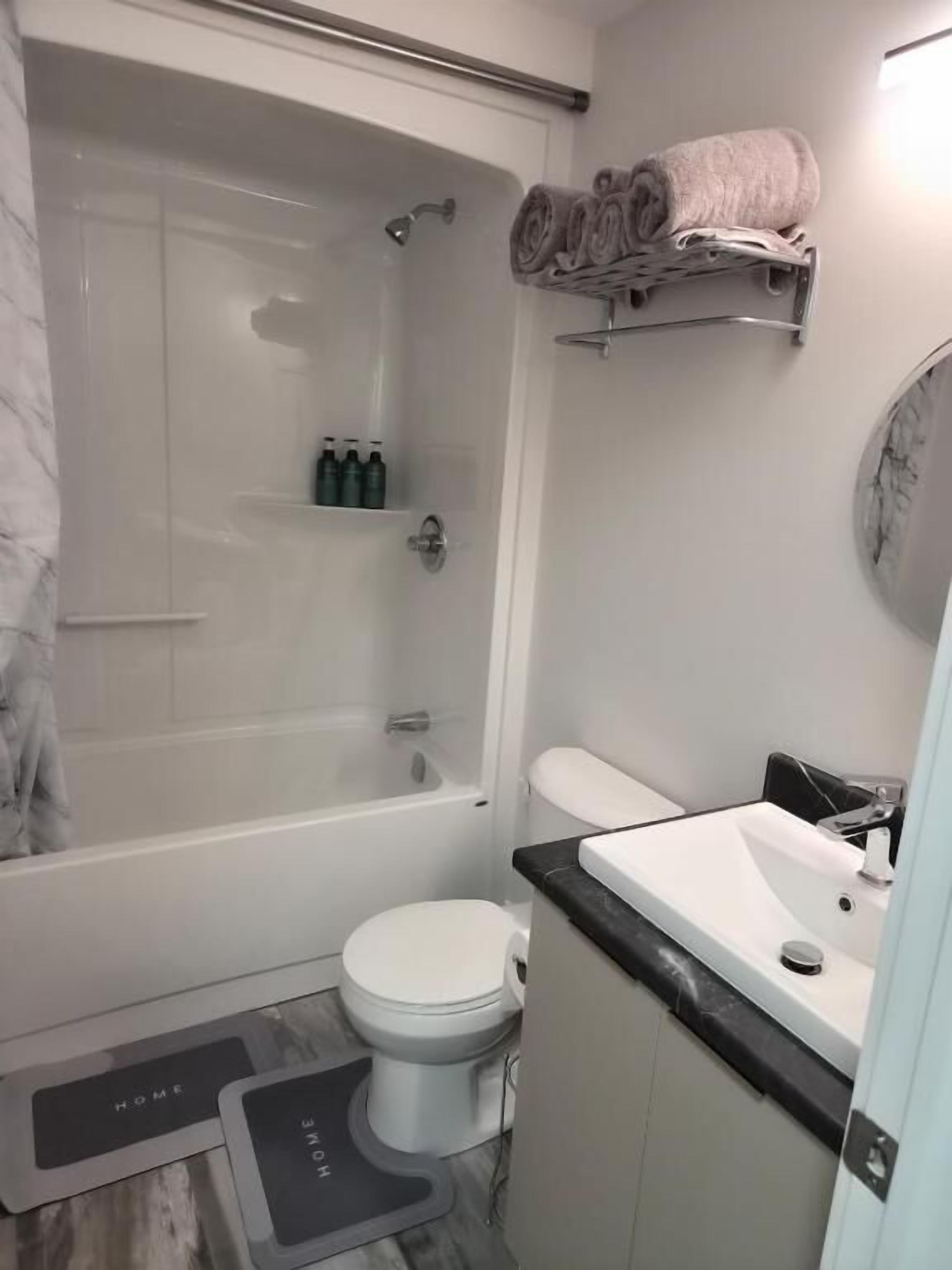 Un baño con bañera, inodoro, lavamanos y cortina de ducha.