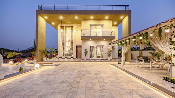 Un edificio moderno con un amplio patio, ventanas grandes y un balcón.